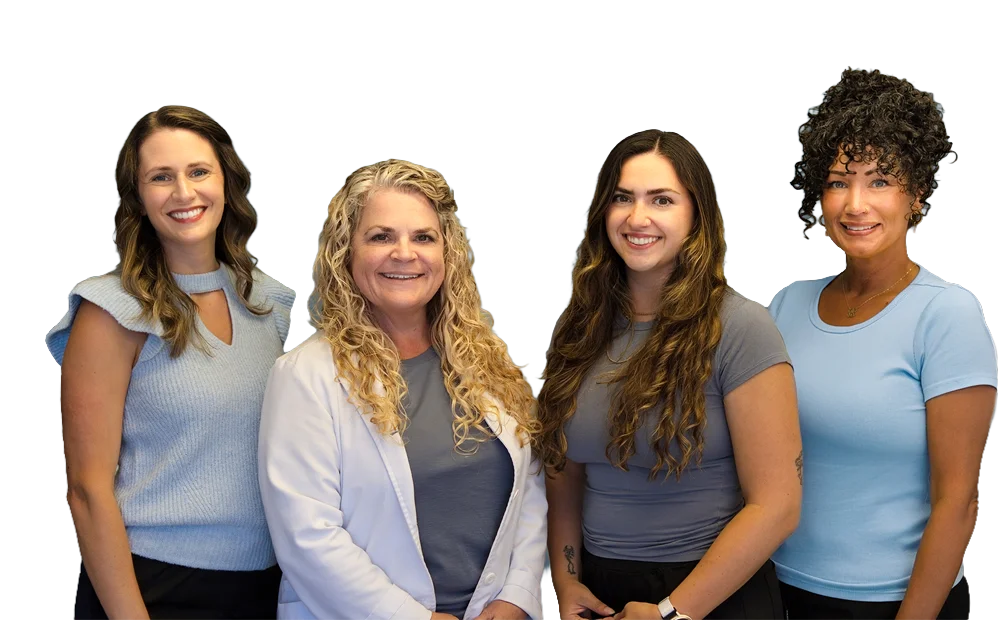 Chiropractic team members Candice, Joy McClenny, Caleigh, and Kim standing together.