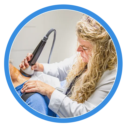 Joy McClenny applying stemwave therapy to a patient’s shoulder.