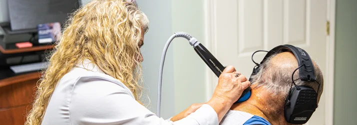 Chiropractor Joy McClenny applying a stemwave therapy device to a patient’s neck.